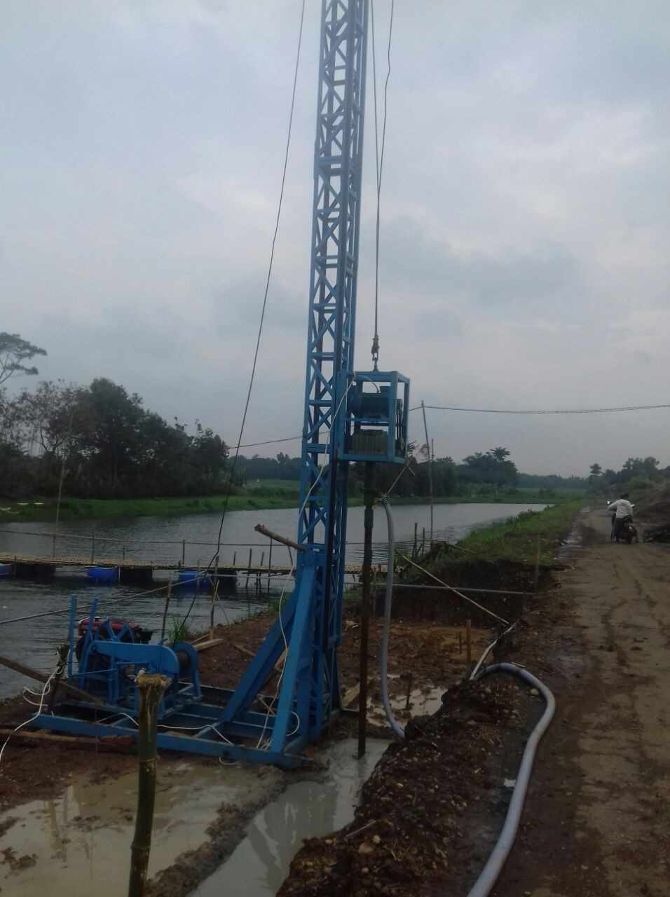 Proyek bore pile mini crane di samping sungai untuk pembuatan jembatan kecil